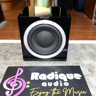 B&W ASW 10CM subwoofer in gloss black — front view with the grille removed, showing the 10-inch driver