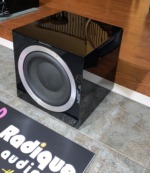 B&W ASW 10CM subwoofer — angled view showing the gloss black cabinet and driver surround