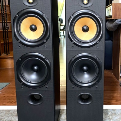 B&W DM603 three-driver floorstanding speakers, pair — front view showing the yellow Kevlar midrange and dual woofers