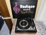 Dual 1214 turntable seen from above at a distance, full deck in view with the platter, tonearm and control plate