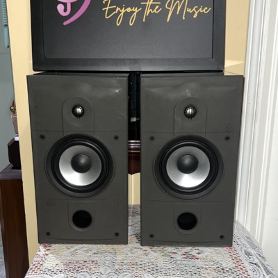Energy Connoisseur C-2 bookshelf speakers in high gloss black with grilles off, showing the tweeter, silver-cone woofer and front bass port