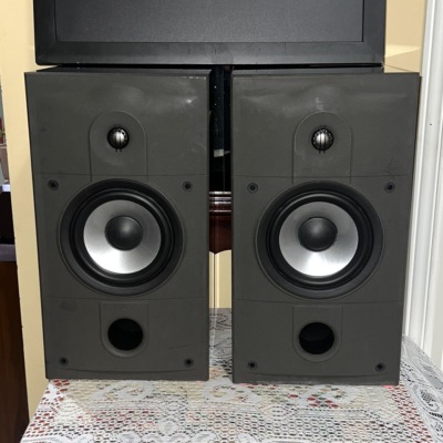 Energy Connoisseur C-2 bookshelf speakers in high gloss black with grilles off, showing the tweeter, silver-cone woofer and front bass port