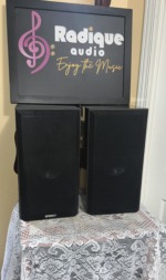 Energy Connoisseur C-2 bookshelf speakers in high gloss black with black cloth grilles on and the Energy badge at the foot of each grille