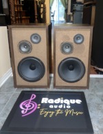 Fisher XP-65S speakers in walnut cabinets with the grilles off, tan baffles carrying a large woofer below a paired midrange and tweeter