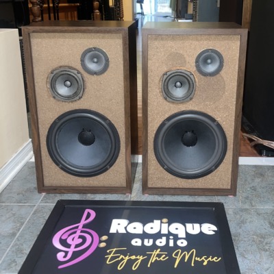 Fisher XP-65S speakers in walnut cabinets with the grilles off, tan baffles carrying a large woofer below a paired midrange and tweeter