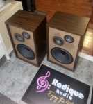 Pair of Fisher XP-65S speakers turned at an angle, walnut veneer sides and tops visible beside the tan driver baffles