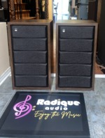 Fisher XP-65S speakers with the ribbed dark grilles fitted, walnut cabinets framing the full-height grille panels