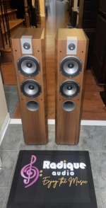 Pair of Focal Chorus 714V towers at a slight angle, Light Walnut cabinets with the full driver array and tweeter faceplate in view
