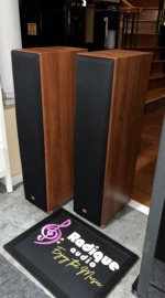 JBL Northridge E80 towers with black grilles fitted, angled to show the cherry cabinet sides