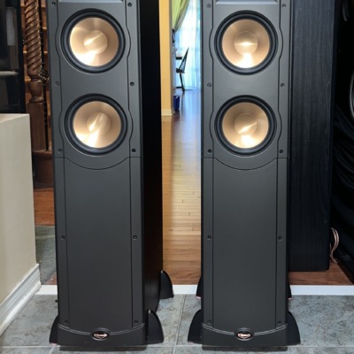 Pair of Klipsch RF-62 floorstanding speakers square on with grilles off, horn-loaded tweeter above two copper-spun woofers on each black tower