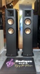 Pair of Klipsch RF-62 floorstanding speakers square on with grilles off, horn-loaded tweeter above two copper-spun woofers on each black tower