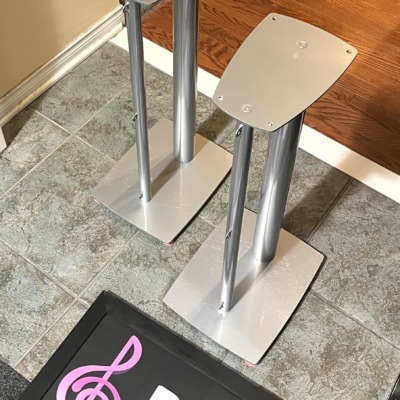 Linn silver metal speaker stands from the side, showing the twin pillars, shaped top plates and wide base plates