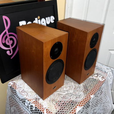 Linn Katan speakers from above and to the right, wood veneer top panels and side walls in view with the Radique Audio board leaning behind them