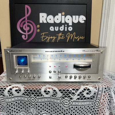 Marantz 2130 tuner powered on, blue dial glowing and a trace on the oscilloscope screen, rows of silver toggle switches and rotary knobs below