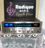 Marantz 2245 stereo receiver, front view, brushed aluminum faceplate with the blue-lit gyro tuning dial and tuning meters illuminated, row of silver control knobs below.