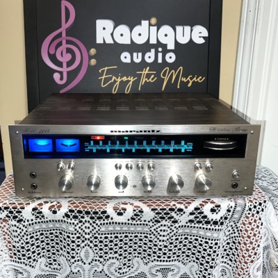Marantz 2245 stereo receiver, front view, brushed aluminum faceplate with the blue-lit gyro tuning dial and tuning meters illuminated, row of silver control knobs below.