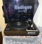 Marantz Model 6200 turntable at an angle with the dust cover raised, showing the platter, tonearm and cartridge