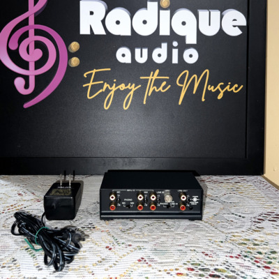 Rear of the NAD PP 3 phono preamp showing the MC and MM RCA inputs, ground post, line in and line out jacks, with its power adapter alongside