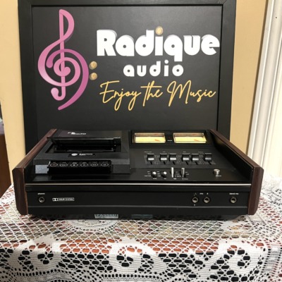 Nakamichi 500 cassette deck, black top panel with twin yellow-lit VU meters, slider level controls and transport keys, dark wood end cheeks