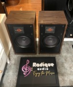 Original Large Advent speakers seen from above and to the left, grilles off, with the walnut cabinet tops and side panels in view