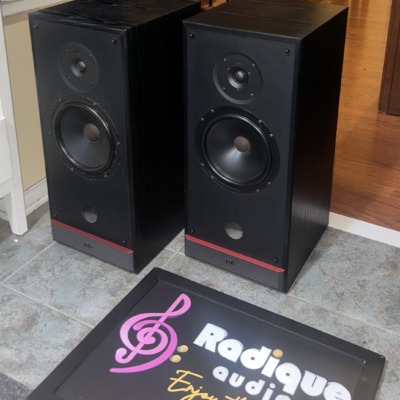 PSB 50 MkII speakers at an angle, grilles off, showing the black ash cabinets, drivers and red base trim
