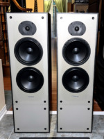Paradigm 11se Mk II floorstanding speakers, grilles off, pale grey baffles with a dome tweeter above two black woofers in black cabinets