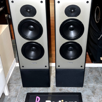 Paradigm 11se Mk II towers viewed from slightly above and left, black cabinet tops and grey three-driver baffles on the Radique Audio board
