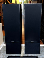Paradigm 11se Mk II floorstanding speakers with grilles on, straight-on view of the black fabric fronts and small Paradigm badges