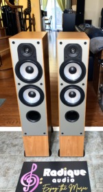 Pair of Paradigm Monitor 7 v2 tower speakers in light cherry, grilles off, tweeter over three woofers on silver baffles