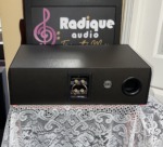 Rear of the Paradigm Studio CC v2 showing the bi-wire gold binding posts with jumpers, a Magne-Shield label and the rear bass port