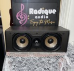 Paradigm Studio CC v2 center channel speaker with the grille off, twin woven woofers either side of a dome tweeter in a black cabinet