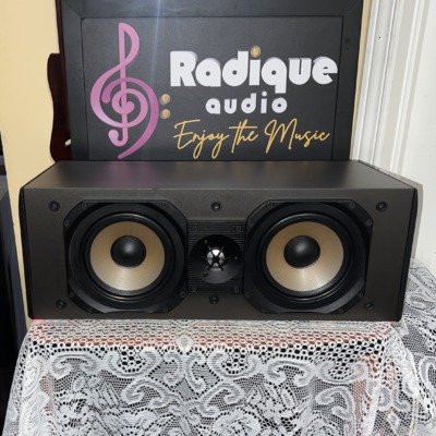 Paradigm Studio CC v2 center channel speaker with the grille off, twin woven woofers either side of a dome tweeter in a black cabinet