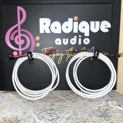 Both Radique House Quad cable runs laid flat against the Radique Audio board, twisted red and black tails fanned out to gold-pin banana plugs