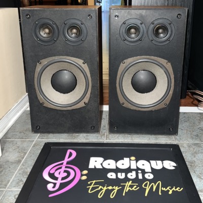 Pair of Realistic Optimus-21 three-way speakers, grilles off, twin tweeters above a large woofer, walnut-grain sides