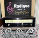 Sansui TU-5900 AM/FM stereo tuner, black faceplate with a backlit tuning scale, twin signal meters and a large centre tuning knob