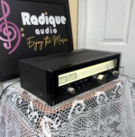 Sansui TU-5900 tuner turned to the right, showing the lit dial glass, the output level knob and the depth of the black chassis