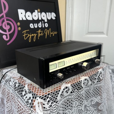 Sansui TU-5900 tuner turned to the right, showing the lit dial glass, the output level knob and the depth of the black chassis
