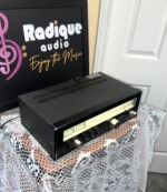 Sansui TU-5900 tuner seen from above and to the left, vented top cover in view with the lit dial and meters below it