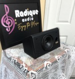 Tannoy D5C centre speaker in black ash at an angle, grille off, on lace by the Radique board