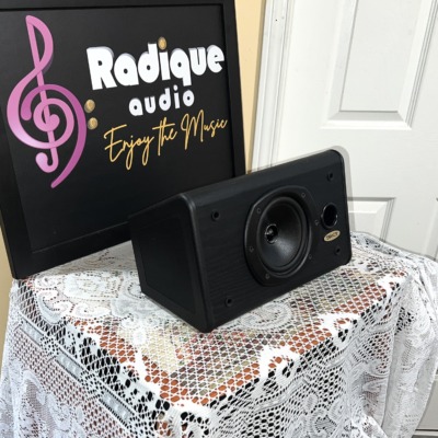 Tannoy D5C centre speaker in black ash at an angle, grille off, on lace by the Radique board