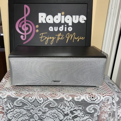 Tannoy Mercury mxC-M centre speaker in dark oak with the silver-grey cloth grille fitted, Tannoy badge centred on the lower edge