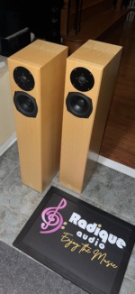 Totem Sttaf floorstanders from the right side in maple, narrow cabinets standing on a tiled floor