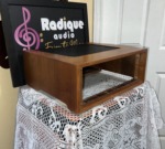 WC-1 size cherry-tone wood cabinet from the front left corner, wood grain along the side, vented top and the framed front opening