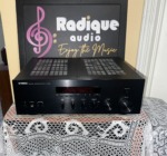 Yamaha R-S300 Natural Sound stereo receiver in black, with its red display window, bass and treble sliders and a large volume knob