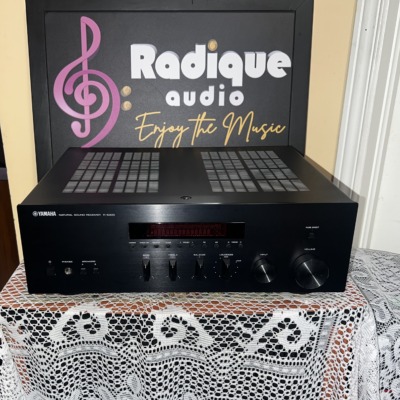 Yamaha R-S300 Natural Sound stereo receiver in black, with its red display window, bass and treble sliders and a large volume knob