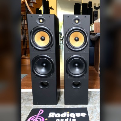 B&W DM603 three-driver floorstanding speakers, pair — front view showing the yellow Kevlar midrange and dual woofers