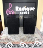 Energy C-50 bookshelf speakers with their black cloth grilles fitted, an Energy logo badge at the foot of each grille