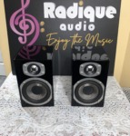 Energy RC-Mini bookshelf speakers in high gloss piano black, front view with the grilles off, showing the Kevlar woofers and aluminum dome tweeters
