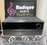 Harman Kardon AVR 340 AV receiver with a silver cabinet and gloss black front panel, large volume knob at the right and a row of buttons along the bottom