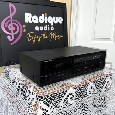 Harman Kardon TD212 cassette deck from the left at an angle, black case with cassette door and front panel controls